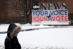 Seseorang berjalan di kampus Saint Anselm College, Jumat, 7 Februari 2020, menjelang debat partai Demokrat di Manchester, N.H. (Foto: AP / Matt Rourke)