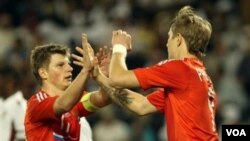 Roman Pavlyuchenko, kanan, merayakan golnya dengan Andrey Arshavin dalam laga persahabatan melawan Qatar di Stadion Al-Sadd, Doha hari Selasa (29/3).