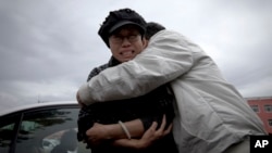 A relative comforts Liu Xia, left, wife of imprisoned Nobel Peace Prize winner Liu Xiaobo, while she cries outside Huairou Detention Center where her brother Liu Hui has been jailed in Huairou district, on the outskirts of Beijing, June 9, 2013. 