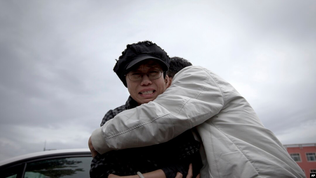 Seorang kerabat berupaya menenangkan Liu Xia (kiri), istri pemenang Nobel Perdamaian asal China yang dipenjara, Liu Xiaobo, saat menangis di luar penjara Huairou, luar kota Beijing, China (9/6). Kakak Liu Hua, Liu Hui, divonis penjara 11 tahun terkait tuduhan melakukan kecurangan dalam masalah perumahan. (9/6).