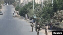 FILE - Troops in Eritrean uniforms walk in the town of Bizet, Ethiopia, March 14, 2021.