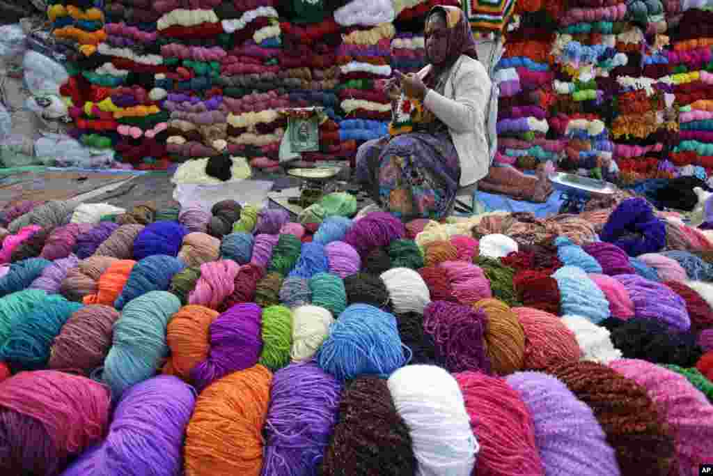 A woman crochets as she sells wool in Ahmadabad, India.