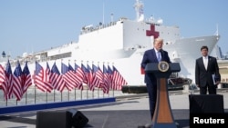 Presiden AS Donald Trump memberi sambutan saat upacara pelepasan kapal rumah sakit USNS Comfort yang akan berlayar ke New York untuk membantu penanganan wabah virus corona, Pangkalan AL Norfolk, Virginia, 28 Maret 2020. (Foto: Reuters)