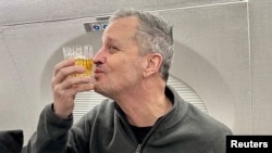 Marc Fogel, an American teacher detained in Russia since August 2021, celebrates his release on an airplane flying him back to the United States, Feb. 11, 2025. (Adam Boehler/Handout via Reuters)