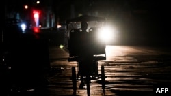 A Cuban rides a bike on a street at night during a nationwide blackout caused by a grid failure in Havana on December 4, 2024.