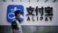 一名保安站在蚂蚁集团支付宝上海办公室的标识前。（2020年9月22日）