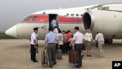 FILE - Passengers board an Air Koryo flight headed for Beijing in Pyongyang, North Korea, June 27, 2016. Air Koryo runs at least one gas station and car wash in Pyongyang, has its own fleet of taxis and operates several retail shops, including a boutique at the airport. 