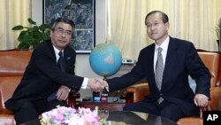 Japanese nuclear envoy Shinsuke Sugiyama, left, shakes hands with his South Korean nuclear envoy Lim Sung-nam before their meeting at Foreign Ministry in Seoul, South Korea, January 12, 2012.