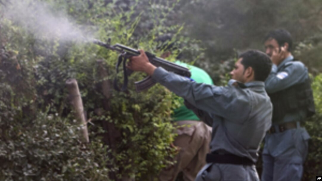 Afghan policemen fire towards a building which the Taliban insurgents took over, during an attack near the U.S. Embassy in Kabul, September 13, 2011.