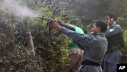 Afghan policemen fire towards a building which the Taliban insurgents took over, during an attack near the U.S. Embassy in Kabul, September 13, 2011.