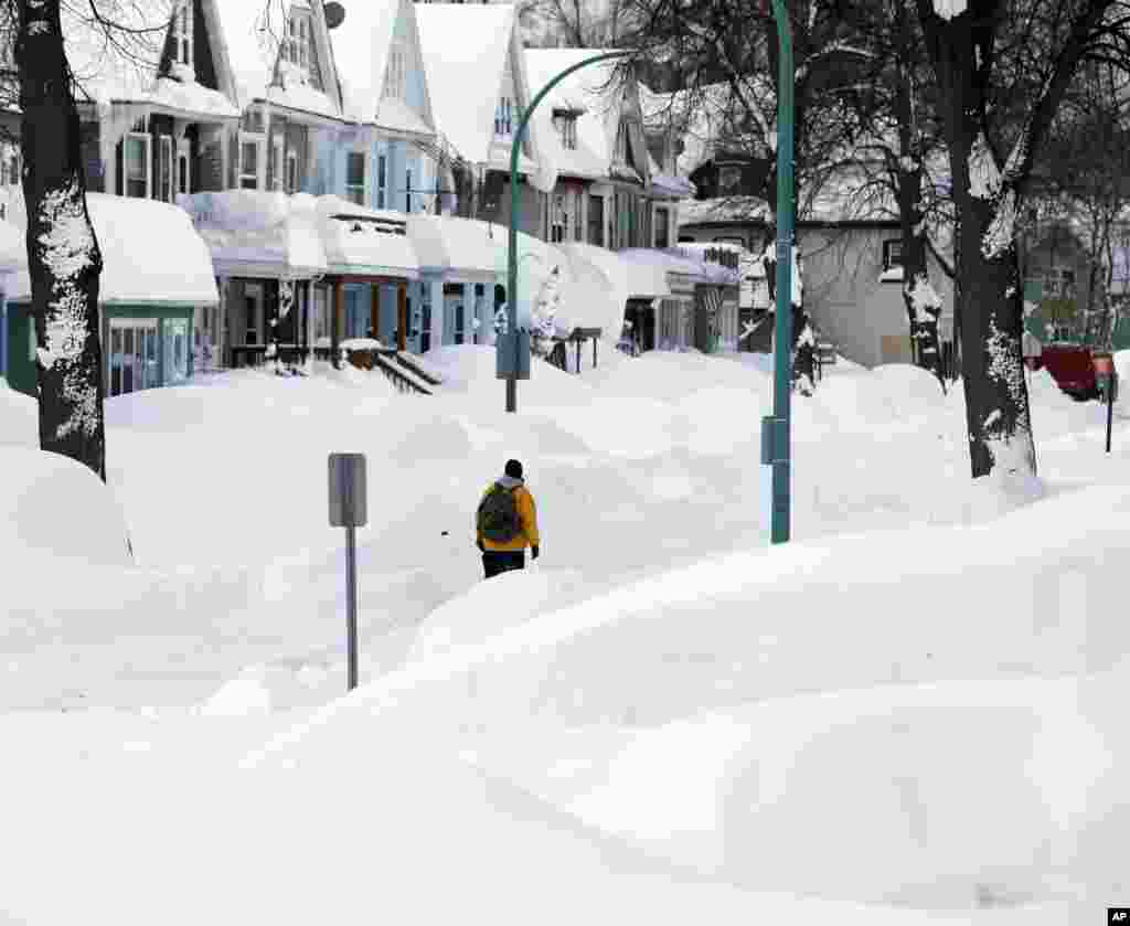 Brian Cintron walks in his snow-bound south Buffalo neighborhood, Nov. 20, 2014, in Buffalo, N.Y.