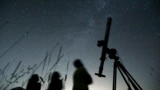 FILE - People look up to the sky from an observatory near the village of Avren, Bulgaria, Aug. 12, 2009. (AP Photo/Petar Petrov, File)