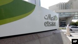 A man walks past a sign at the headquarters of telecommunications company Etisalat in Dubai (2011 File)