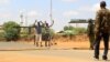 Civilians approach security officers to be questioned at a roadblock near the site where gunmen abducted two Cuban doctors as they were on their way to work, in Mandera county, Kenya, April 12, 2019.