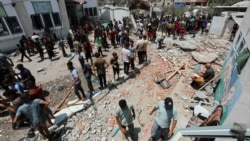 Palestinians inspect a school sheltering displaced people following an Israeli strike in Deir al Balah in the central Gaza Strip on July 27, 2024.