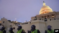 FILE - Police form a line to guard the Capitol after rioters stormed the Capitol, in Washington, Jan. 6, 2021.