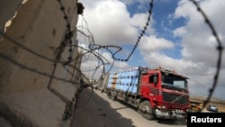 FILE - A truck carrying goods arrives at Kerem Shalom crossing in Rafah in the southern Gaza Strip, Aug. 15, 2018. 