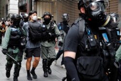 Agentes de la policía antidisturbios detienen a un manifestante antigubernamental durante una protesta en el Distrito Central en Hong Kong