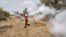 A Palestinian protester returns a tear gas canister fired by Israeli troops during clashes over tension in Jerusalem's al-Aqsa mosque, in the occupied West Bank village of Budrus near Ramallah, October 2, 2015.