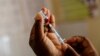 FILE — A nurse fills a syringe with malaria vaccine before administering it to a patient.