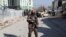FILE - An Afghan security officer stands guard at the site of a bomb blast in Kabul, Afghanistan, Dec. 15, 2020. Another explosion on Dec. 18, 2020, killed at least 15 civilians in eastern Ghazni province, Afghan officials reported. 
