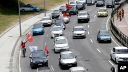 Demonstrators take part in a caravan to protest against the government's response to the COVID-19 pandemic and demand the removal of Brazilian President Jair Bolsonaro, in Rio de Janeiro, Brazil, Jan. 31, 2021.