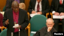 The Archbishop of York, John Sentamu (L), speaks next to the Archbishop of Canterbury Justin Welby at the General Synod in Church House in central London, England, Nov. 20, 2013