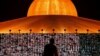 People pray as screens show devotees gathering via Zoom application during a ceremony to commemorate the Buddhist Lent Day at the Wat Phra Dhammakaya temple, amid the COVID-19 outbreaks, in Pathum Thani province, Thailand, July 24, 2021. 