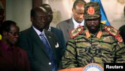 Presiden Sudan Selatan Salva Kiir (kanan) hari Senin (16/12) di Juba, mengumumkan gagalnya upaya kudeta hari Minggu malam oleh pasukan pendukung mantan Wapres Riek Machar.