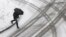 A man crosses the street as a light snow falls in Baltimore, Maryland, Jan. 21, 2014. 