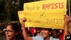 FILE - Siswa India memegang poster dan meneriakkan slogan-slogan dalam sebuah demo untuk meningkatkan kesadaran terhadap kekerasan berbasis gender terhadap perempuan di Mumbai, 10 December 2014. 