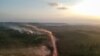 En esta vista aérea, el polvo rojo de la carretera BR230, conocida como "Transamazónica", se mezcla con incendios al atardecer en la localidad agrícola de Ruropolis, estado de Pará, norte de Brasil, el 6 de septiembre de 2019.