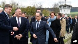 German Foreign Minister Heiko Maas, right, talks with U.S. Secretary of State Mike Pompeo, 2nd left, during their visit at the German village of Moedlareuth near Hof, eastern Germany, Nov. 7, 2019. 