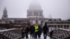 Pedestrians cross The Millennium Bridge with the dome of St Paul's Cathedral disappearing into the fog behind, in London on Dec. 27, 2024.