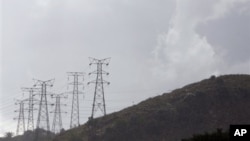 Electricity pylons snake across a hill in a Johannesburg suburb.