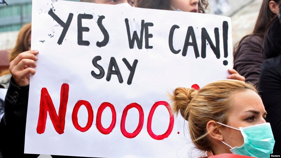 Demonstrators wear masks during a protest against the dismantling of Syria's chemical weapons in Albania, in front of the U.S. embassy in Tirana, November 12, 2013. 