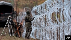 FILE - Polish soldiers lay razor wire along Poland's border with Russian in Wisztyniec, Poland, on Nov. 2, 2022. Polish Prime Minister Donald Tusk announced on May 18, 2024, that Poland would spend $2.5 billion to increase security along its border with Russia and Belarus.