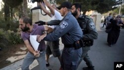 FILE - Israeli police try to restrain a man during a protest outside a hospital where Samir Arbeed, a Palestinian suspect in a deadly West Bank bombing, is being treated, in Jerusalem, Oct. 1, 2019.