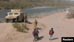 Imagen de archivo de un grupo de migrantes de Venezuela camina a lo largo de las orillas del río Grande en Texas, EEUU.