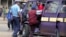 A September 2006 file photo shows a Kenyan policeman boarding a minibus after the vehicle was stopped for a traffic offence in the capital Nairobi.
