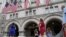 FILE - A group of people approach the front facade of the Trump International Hotel to pose for photos in Washington, July 31, 2019. 