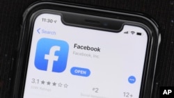 FILE - The social media application, Facebook is displayed on Apple's App Store, July 30, 2019. Facebook is launching a long-promised tool that lets users block the social network from gathering information about them on outside websites and apps.