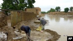 People protect their houses from flood water after torrential rain brought down buildings (file photo - 31 Aug 2010)