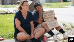 RETRANSMISSION TO CORRECT SPELLING OF SURNAME TO HEBERT - Homeless couple Angelique Hebert, and husband Wilfred Hebert, ask for help on a sidewalk as they try to recover from the effects of Hurricane Ida Tuesday, Aug. 31, 2021, in Houma, La. (AP…