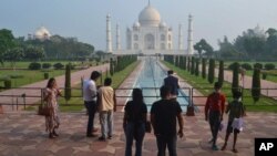 Beberapa wisatawan mengunjungi monumen Taj Mahal di Agra, India saat dibuka kembali untuk umum, Senin (21/9). 