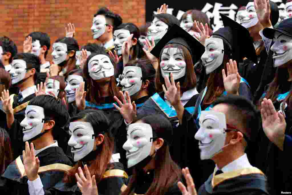 University students wearing Guy Fawkes masks pose for a photoshoot of a graduation ceremony to support anti-government protests at the Hong Kong Polytechnic University, Oct. 30, 2019.