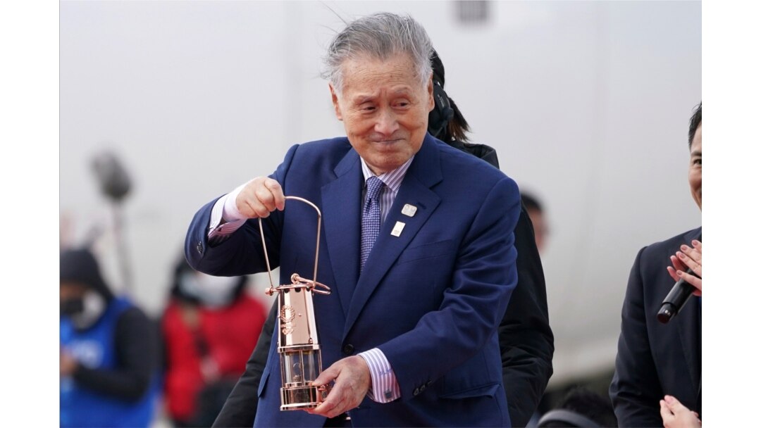 Tokyo 2020 Olympics chief Yoshiro Mori carries the Olympic flame during the Flame Arrival Ceremony at Japan Air Self-Defense Force Matsushima Base in Higashimatsushima in Miyagi Prefecture, north of Tokyo, March 20, 2020.