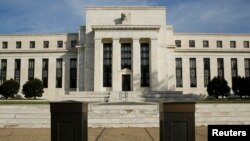 FILE - The U.S. Federal Reserve Board building is shown behind security barriers in Washington.