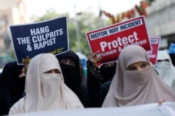 Supporters of religious and political party Jamaat-e-Islami (JI) carry signs against a gang rape that occured along a highway, and to condemn the violence against women and girls, during a demonstration in Karachi, Pakistan, Sept. 11, 2020.