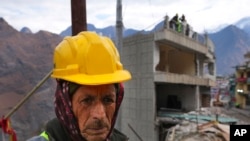 A laborer takes a break in between demolition of a residential building which has developed cracks in Joshimath, in India's Himalayan mountain state of Uttarakhand, Jan. 19, 2023.